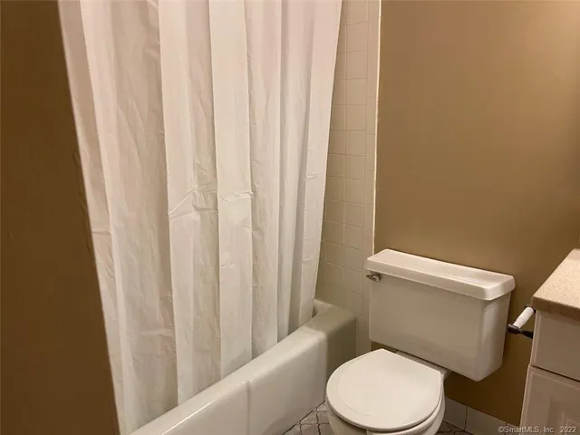 a white toilet sitting next to a shower