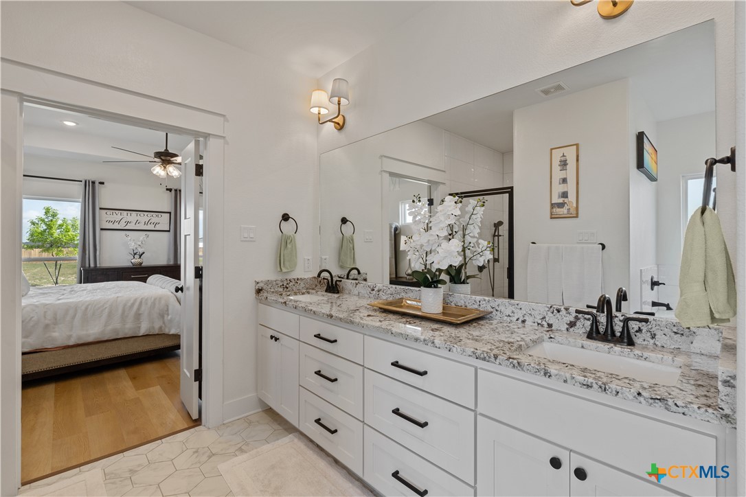 942 Inka Road Salado, TX 76571 - Photo 20 of 46 a bathroom with a granite countertop sink and a mirror