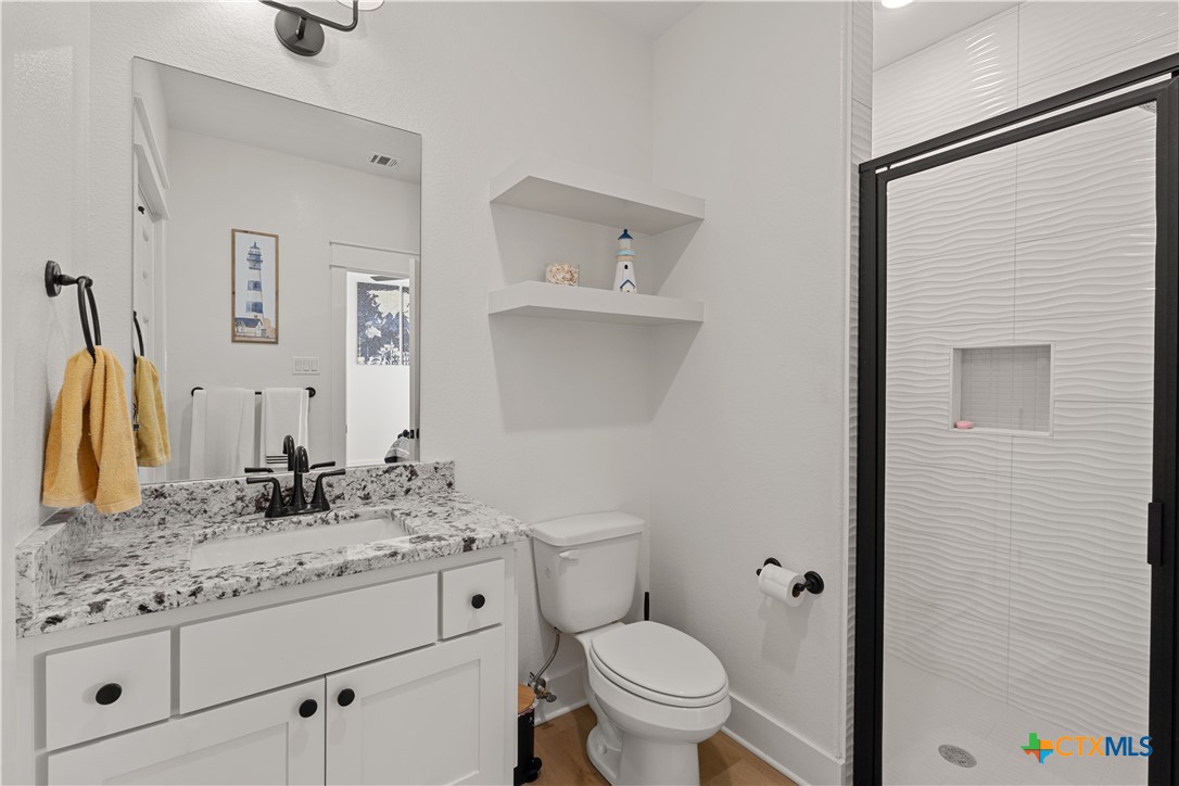 942 Inka Road Salado, TX 76571 - Photo 34 of 46 a bathroom with a granite countertop sink a toilet and a mirror