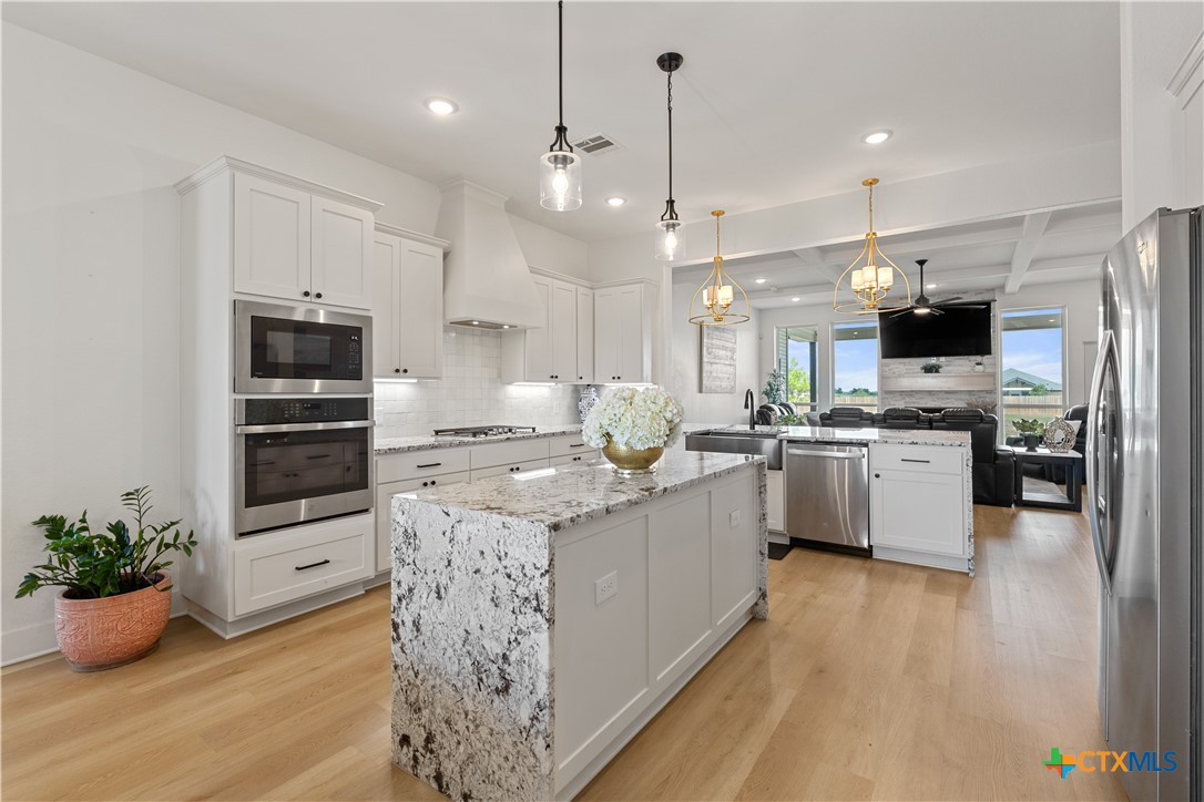 942 Inka Road Salado, TX 76571 - Photo 6 of 46 a kitchen with stainless steel appliances kitchen island granite countertop a stove a sink and a refrigerator