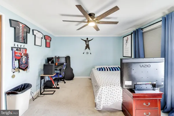 a bedroom with a bed dresser and a chandelier