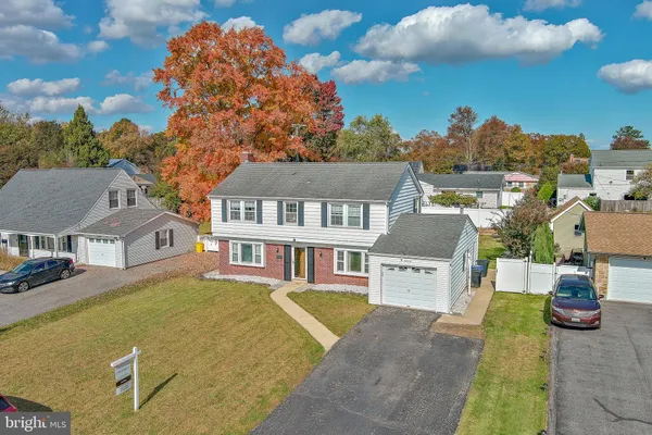 a view of a big house with a large trees and plants