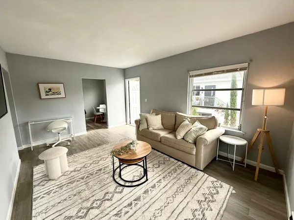 a living room with furniture a dining table and a window