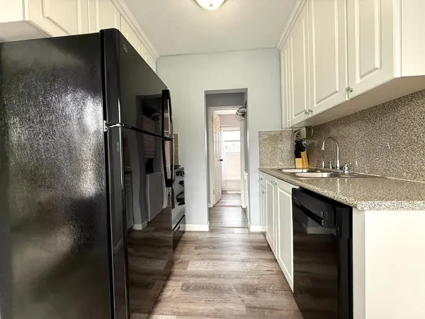 a kitchen with stainless steel appliances granite countertop a refrigerator and a sink