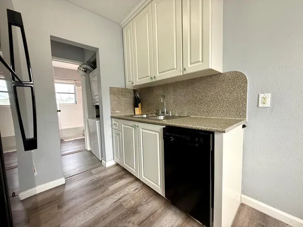 a kitchen with stainless steel appliances a refrigerator and a hard wood floor
