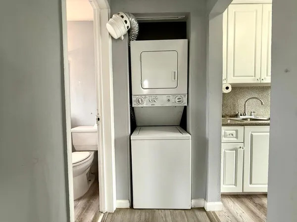 a view of washer and dryer with bathroom in the background