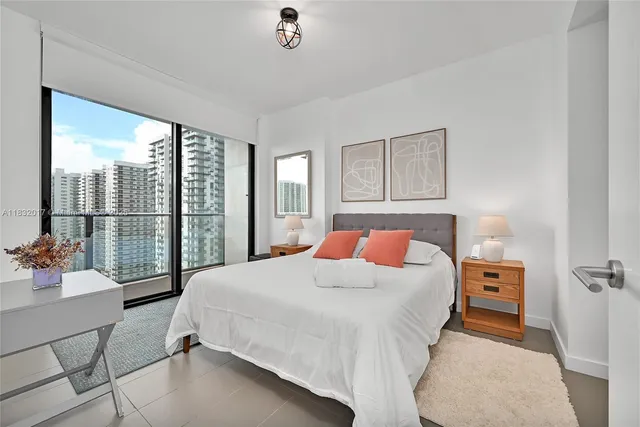 a bedroom with a bed and a large window