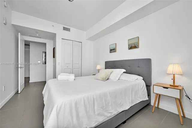 a bedroom with a bed and a lamp