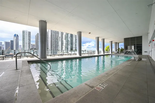 a view of a kitchen with kitchen island stainless steel appliances stove a sink and living room view