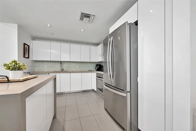 a kitchen with stainless steel appliances granite countertop a refrigerator and a sink