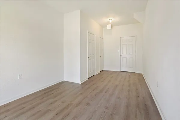 a view of a room with wooden floor and white walls