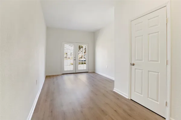 an empty room with wooden floor & closet area