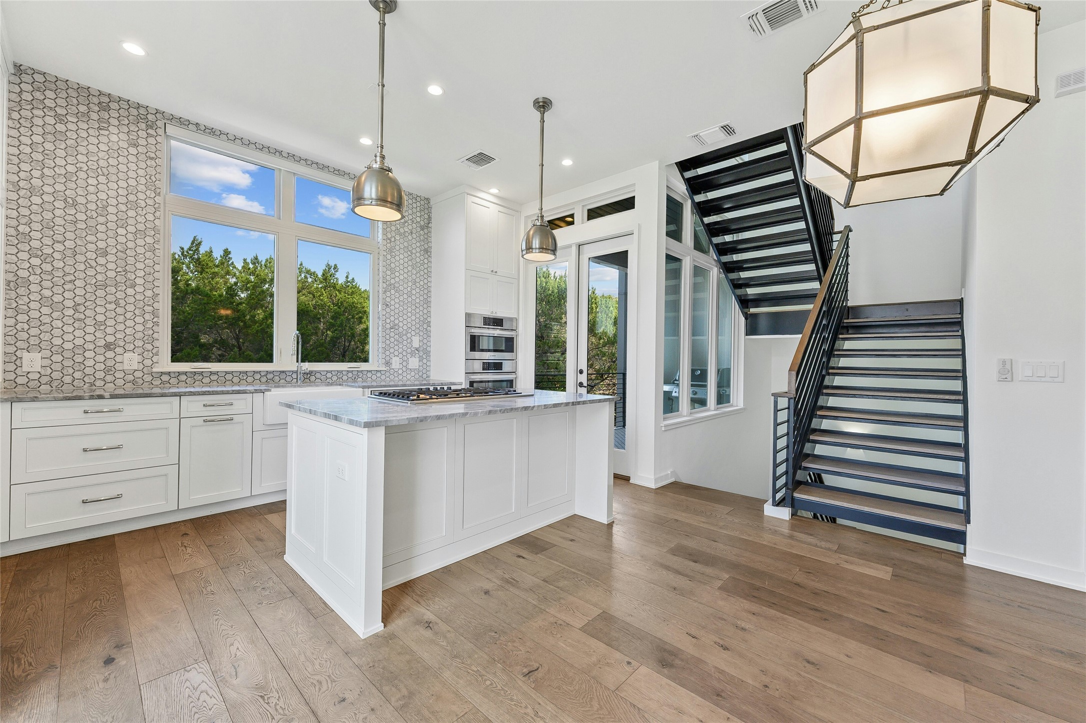 2518 Sutherland Street Austin, TX 78746 - Photo 7 of 30 Culinary aspirations meet modern design in this kitchen, complete with a generous island and sleek appliances.