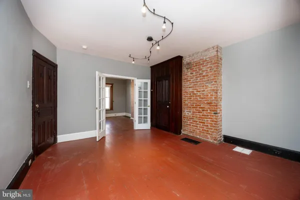 a view of empty room with wooden floor