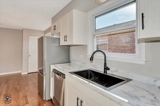 a close view of a sink and a refrigerator in a kitchen