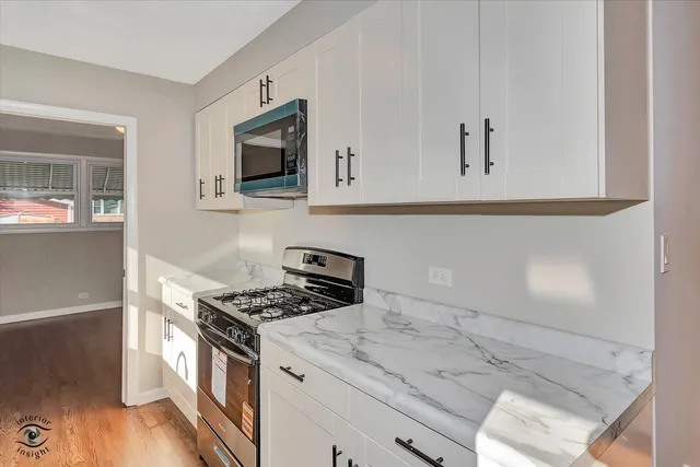 a kitchen with granite countertop white cabinets and white appliances
