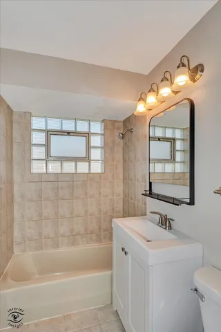 a bathroom with a tub sink and mirror