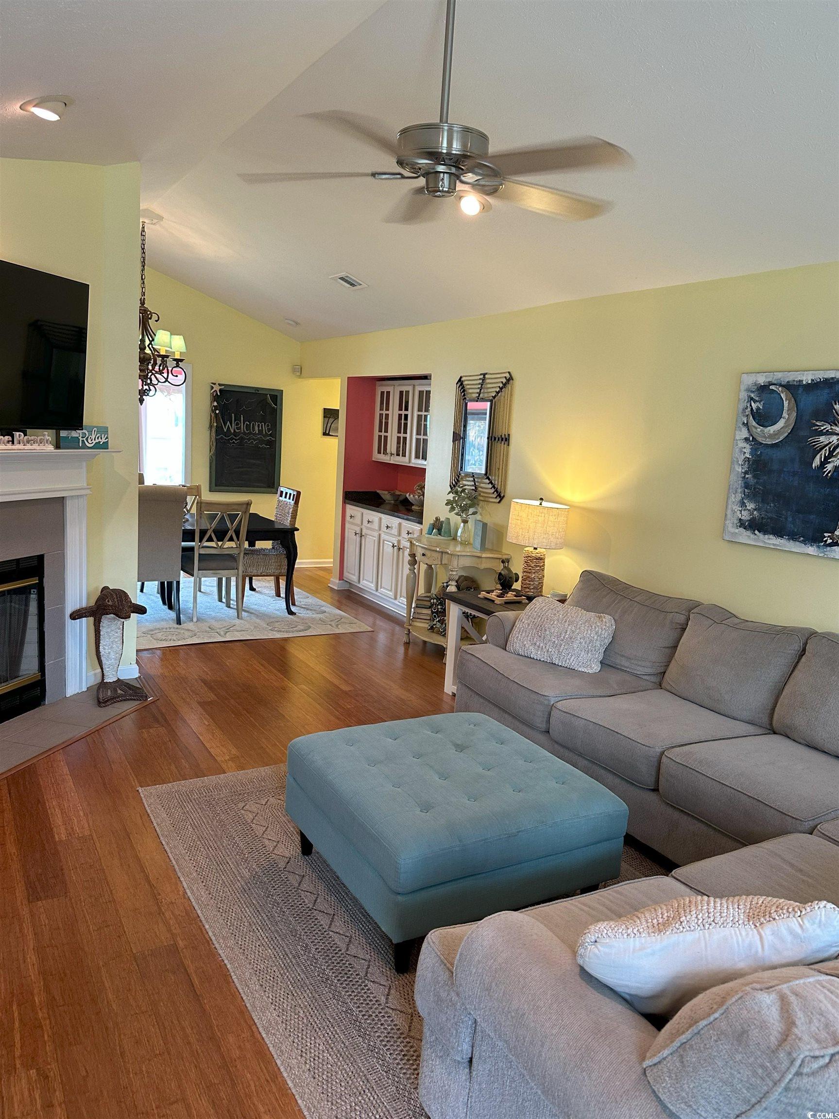 810 Marlin Court Murrells Inlet, SC 29576 - Photo 6 of 40 Living area featuring ceiling fan, a tile fireplace, wood finished floors, and vaulted ceiling