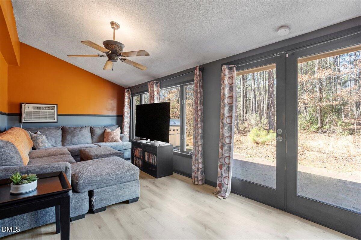 712 Godwin Court Raleigh, NC 27606 - Photo 3 of 27 a living room with furniture a flat screen tv and a large window