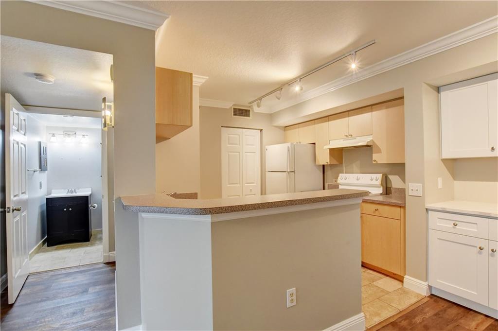 1312 Villa Lane, Unit 1312 Boynton Beach, FL 33435 - Photo 3 of 34 a kitchen with stainless steel appliances granite countertop a sink and cabinets