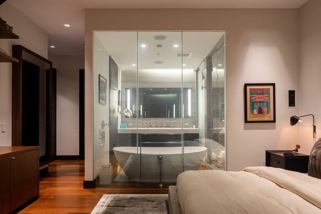 110 Stuart Street, Unit PH04 Boston, MA 02116 - Photo 12 of 36 a bedroom with a large bed and a chandelier