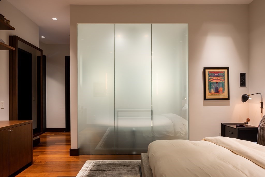 110 Stuart Street, Unit PH04 Boston, MA 02116 - Photo 13 of 36 a bedroom with a bed and a walk in closet