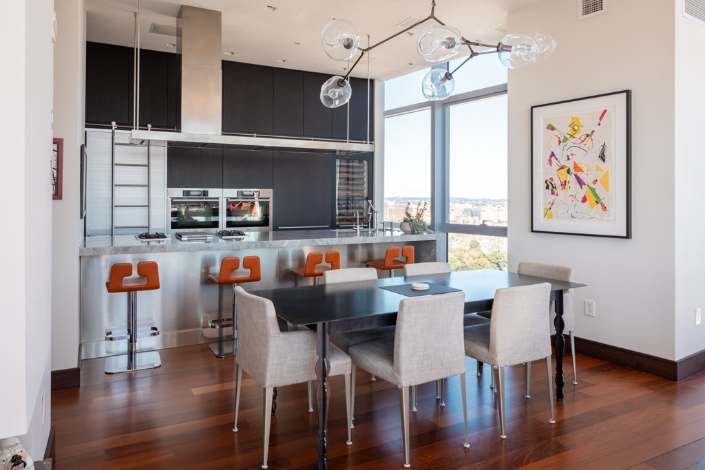 110 Stuart Street, Unit PH04 Boston, MA 02116 - Photo 4 of 36 a dining room with a wooden floor and large windows