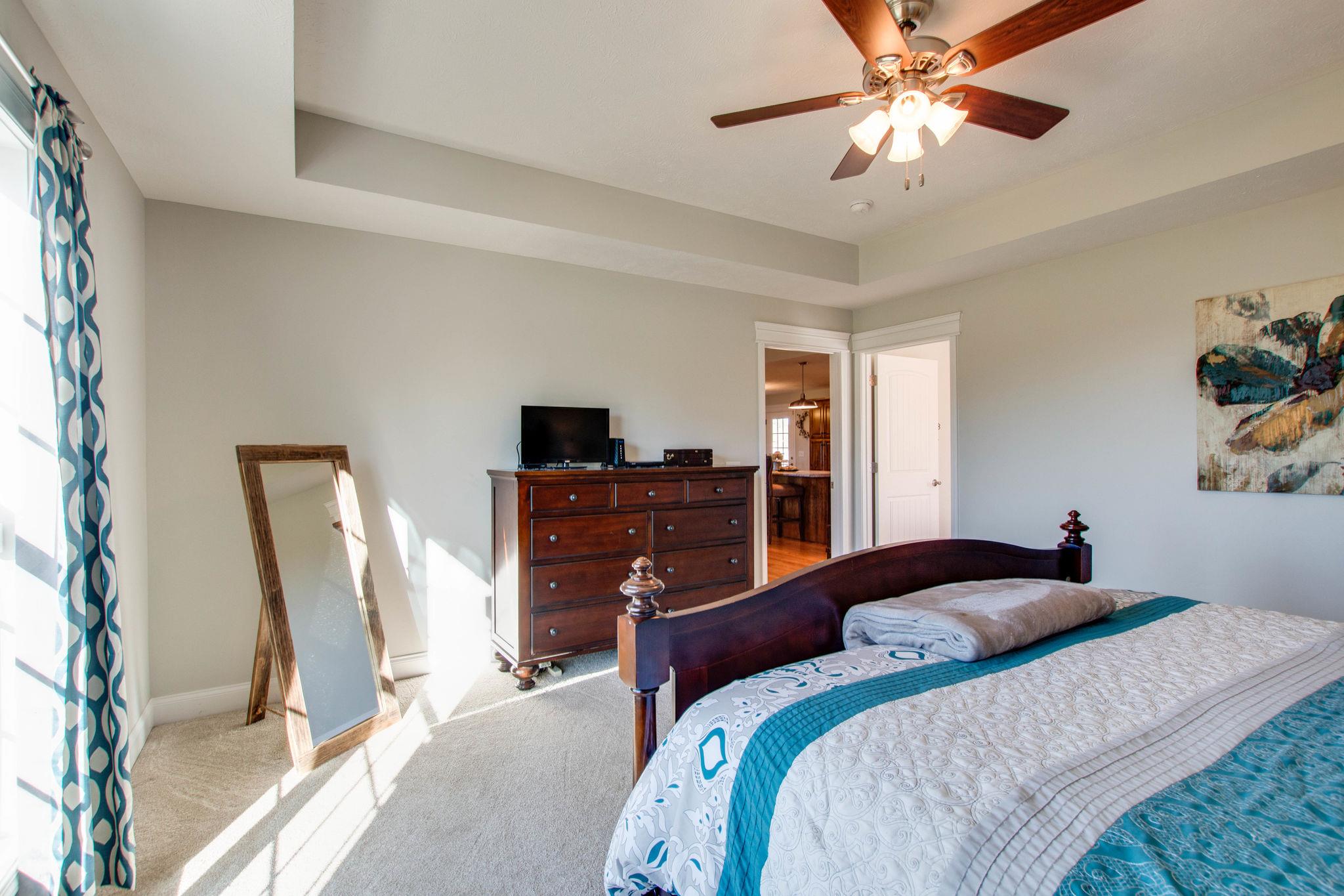 166 Putman Well Road Rockvale, TN 37153 - Photo 13 of 25 a bedroom with a large bed and a chandelier