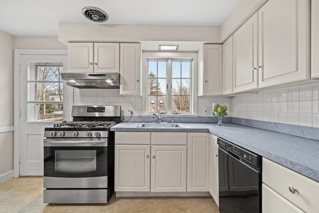 277 Webster Street Needham, MA 02494 - Photo 7 of 17 a kitchen with stainless steel appliances granite countertop a stove a sink and a microwave