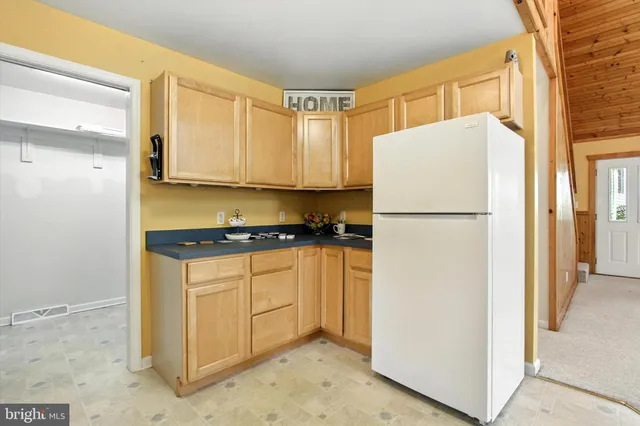 a view of kitchen with refrigerator and window