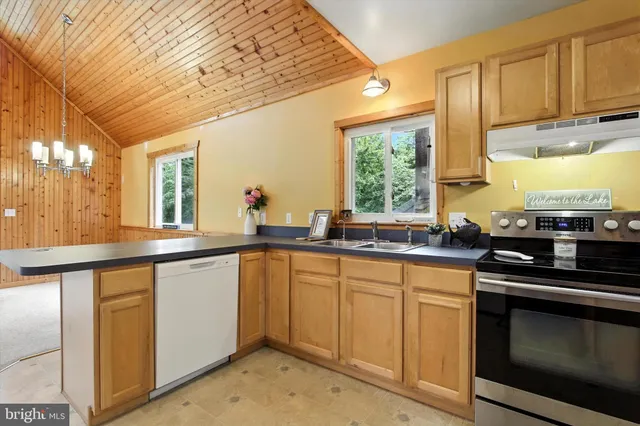 a kitchen with a refrigerator a stove top oven and cabinets