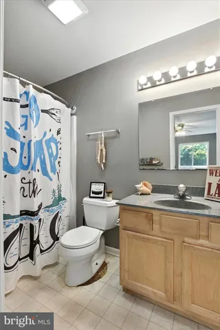 an empty room with windows and ceiling fan