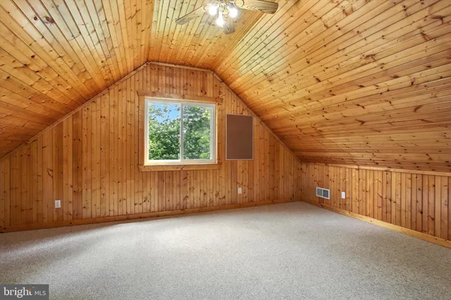 wooden floor with ceiling fan and window
