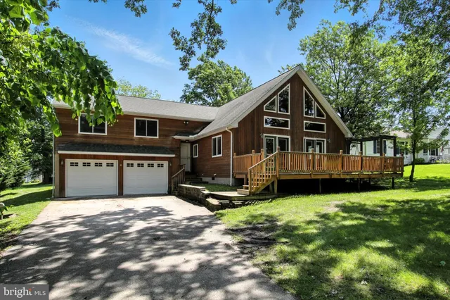 a view of a house with a yard and deck area with a garden