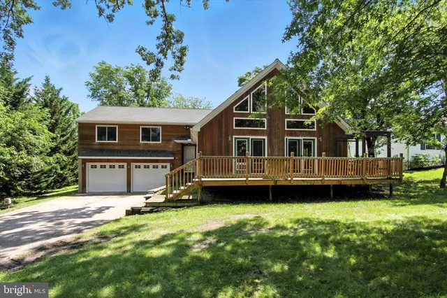 an aerial view of a house with a yard and lake view