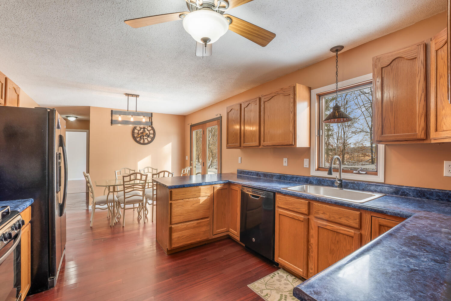 1852 South 100 West Knox, IN 46534 - Photo 4 of 13 a kitchen with stainless steel appliances granite countertop a refrigerator a sink dishwasher a stove and white countertops with wooden floor