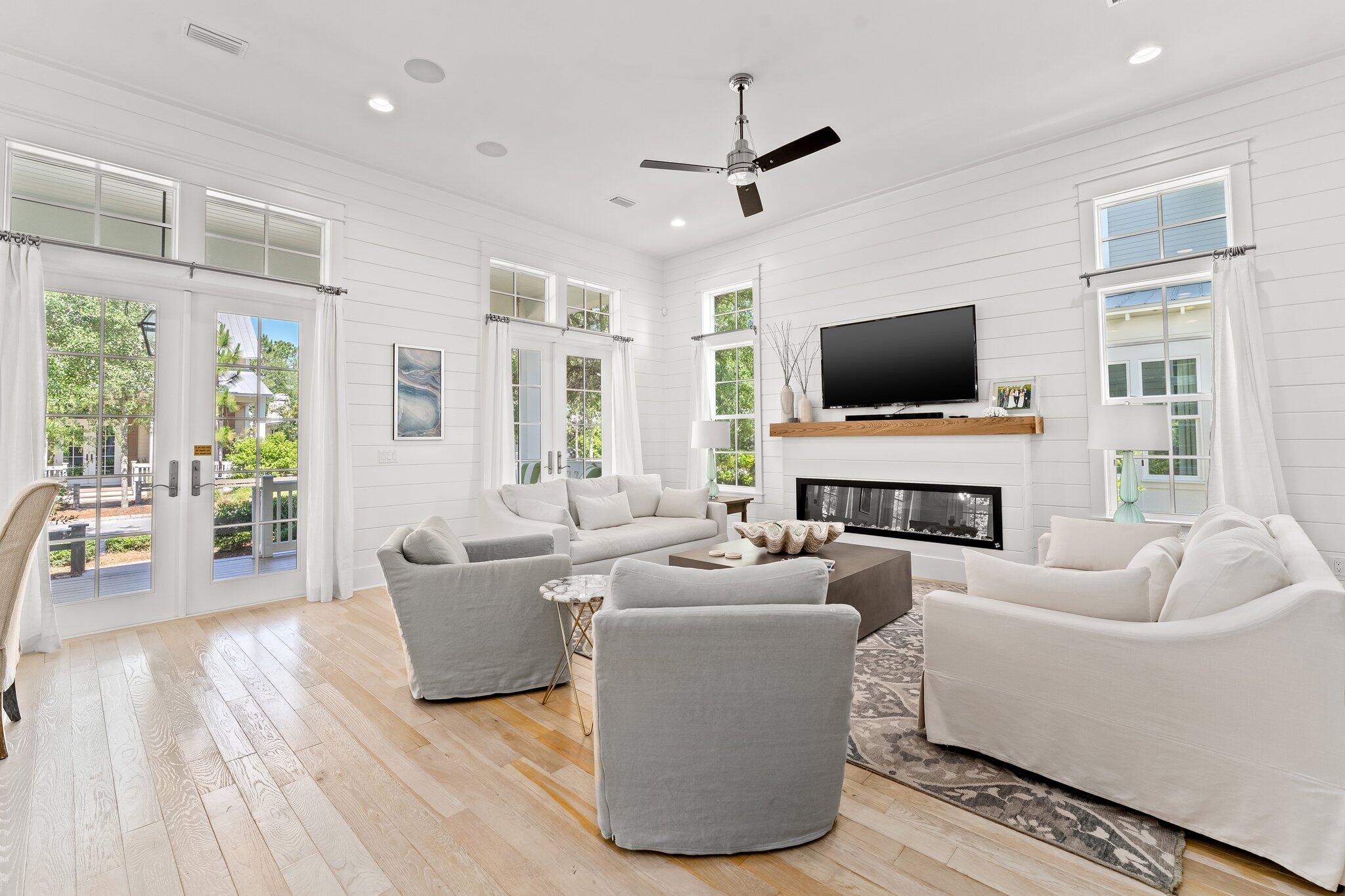 56 South Wisteria Way Santa Rosa Beach, FL 32459 - Photo 18 of 77 a living room with furniture a fireplace a flat screen tv and a large window