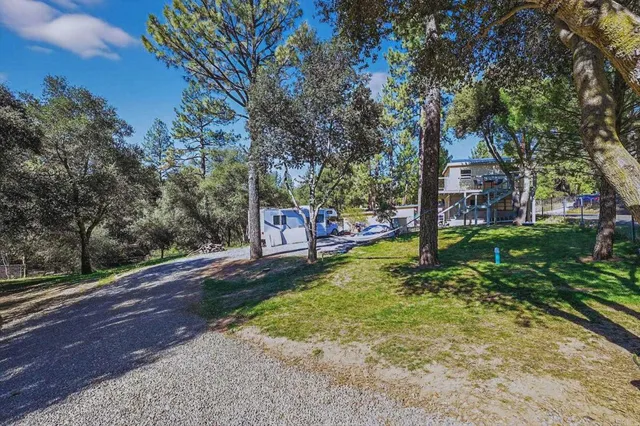 a front view of a house with a yard and trees