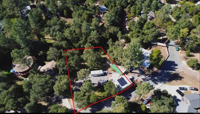 an aerial view of residential house with outdoor space and trees all around