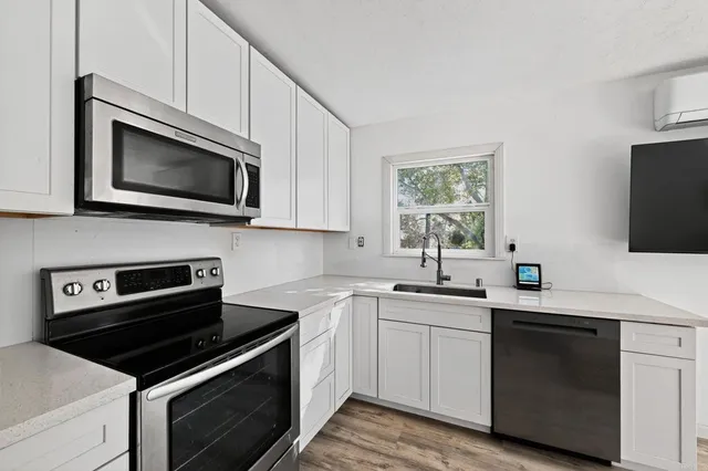 a kitchen with granite countertop cabinets stainless steel appliances and wooden floor
