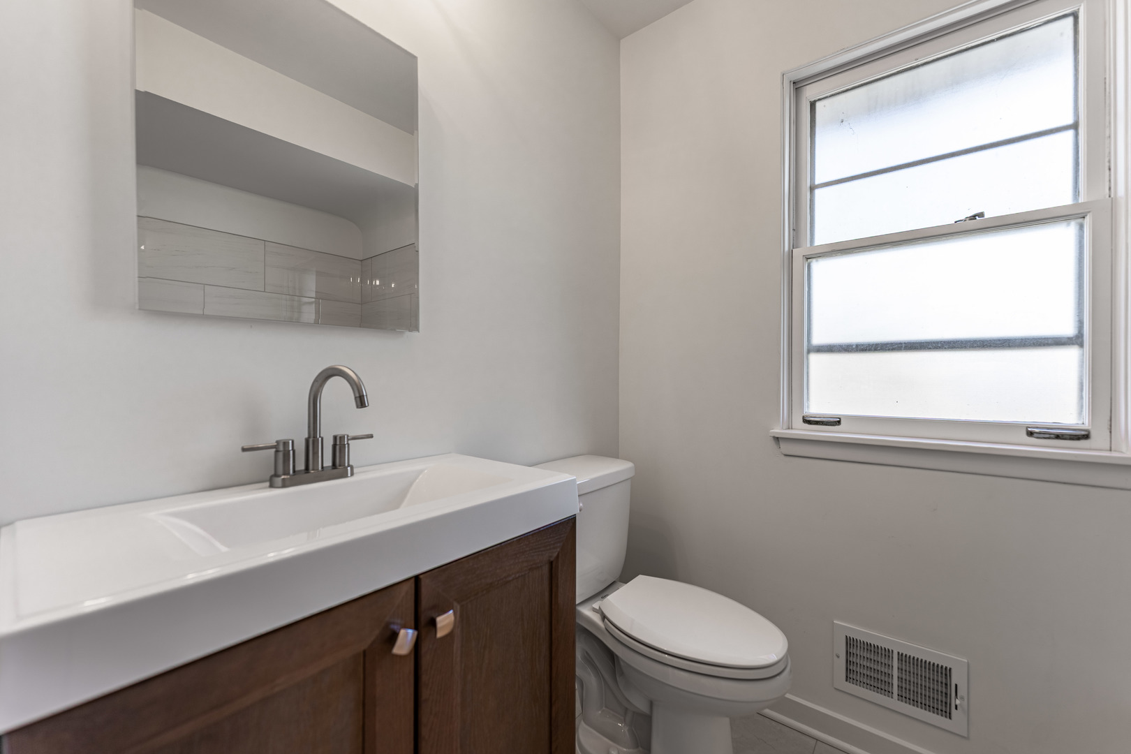 4313 Elm Avenue Lyons, IL 60534 - Photo 16 of 34 a bathroom with a toilet a sink a window and mirror