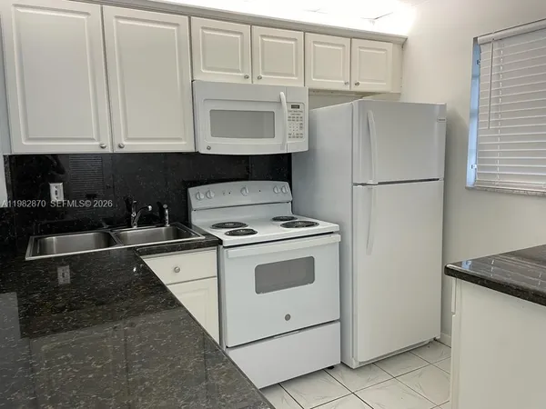 a kitchen with a stove cabinets and refrigerator