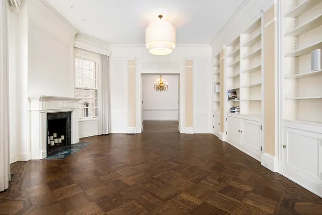 an empty room with windows and fireplace