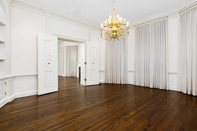 an empty room with wooden floor and mirror