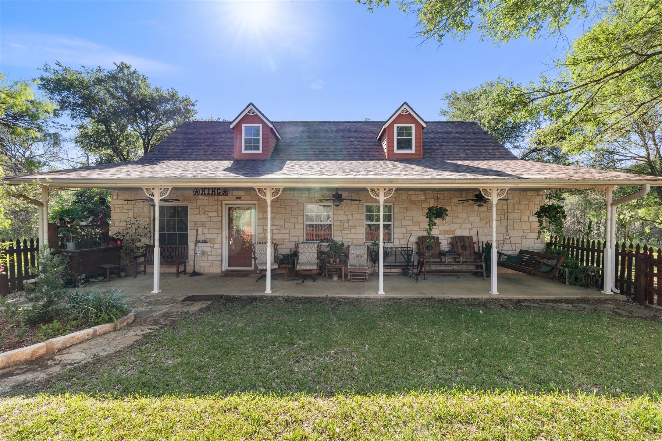 399 Upper Elgin River Road Elgin, TX 78621 - Photo 4 of 39 Front view of house featuring stone siding, covered porch, a shingled roof, and ceiling fan