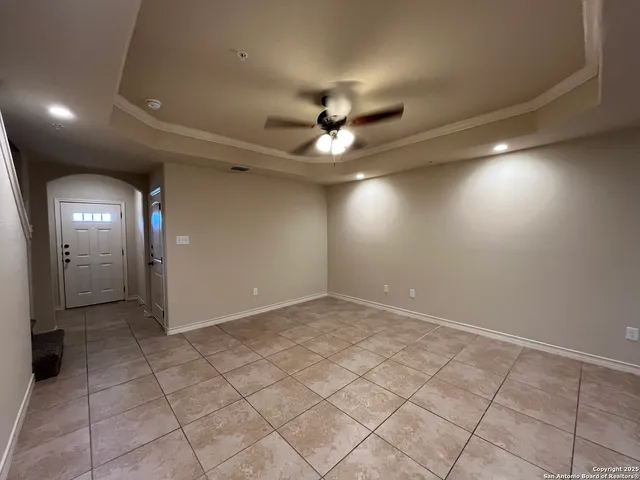 an empty room with fan and glass door