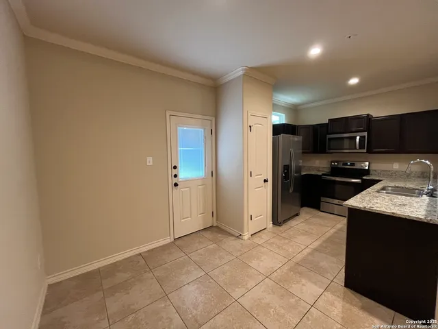 a kitchen with stainless steel appliances granite countertop a refrigerator and a sink