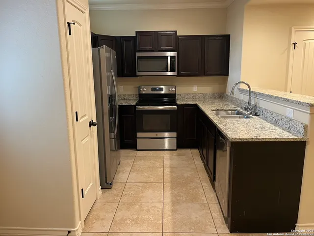 a kitchen with stainless steel appliances granite countertop a stove a sink and a refrigerator