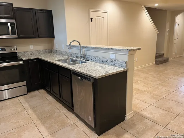 a kitchen with a sink a stove and cabinets