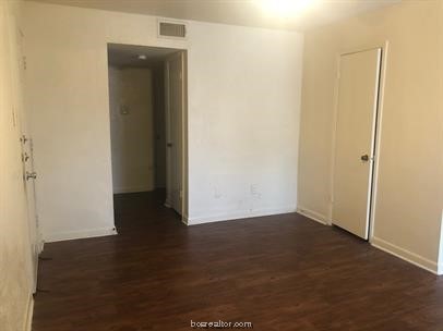 an empty room with wooden floor and closet